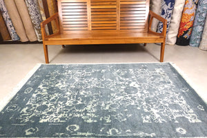 A 6 feet by 4 feet erased rug with floral pattern.