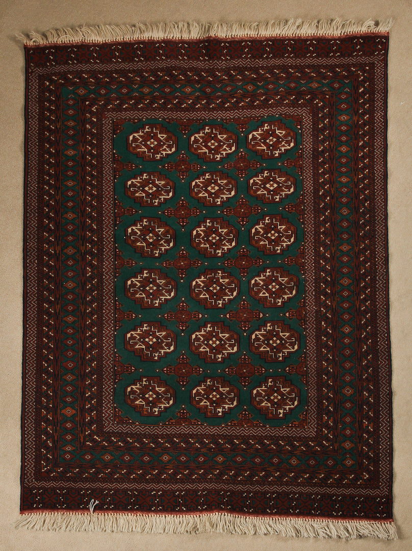 A 4 feet by 6 feet Afghan wool rug, the colours used on the rug are green,brown,black and rust.