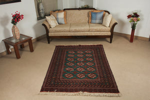 A 4 feet by 6 feet Afghan wool rug, the colours used on the rug are green,brown,black and rust.