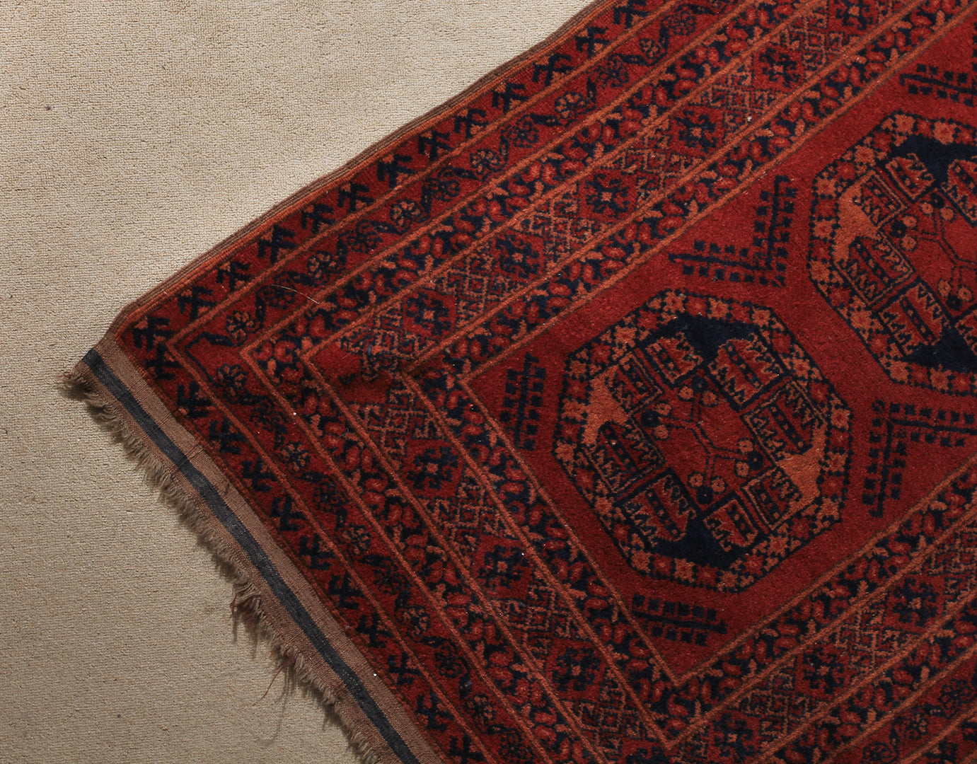A 2.5 feet by 10 feet turkoman wool rug. The colours used are deep red,rust and black.