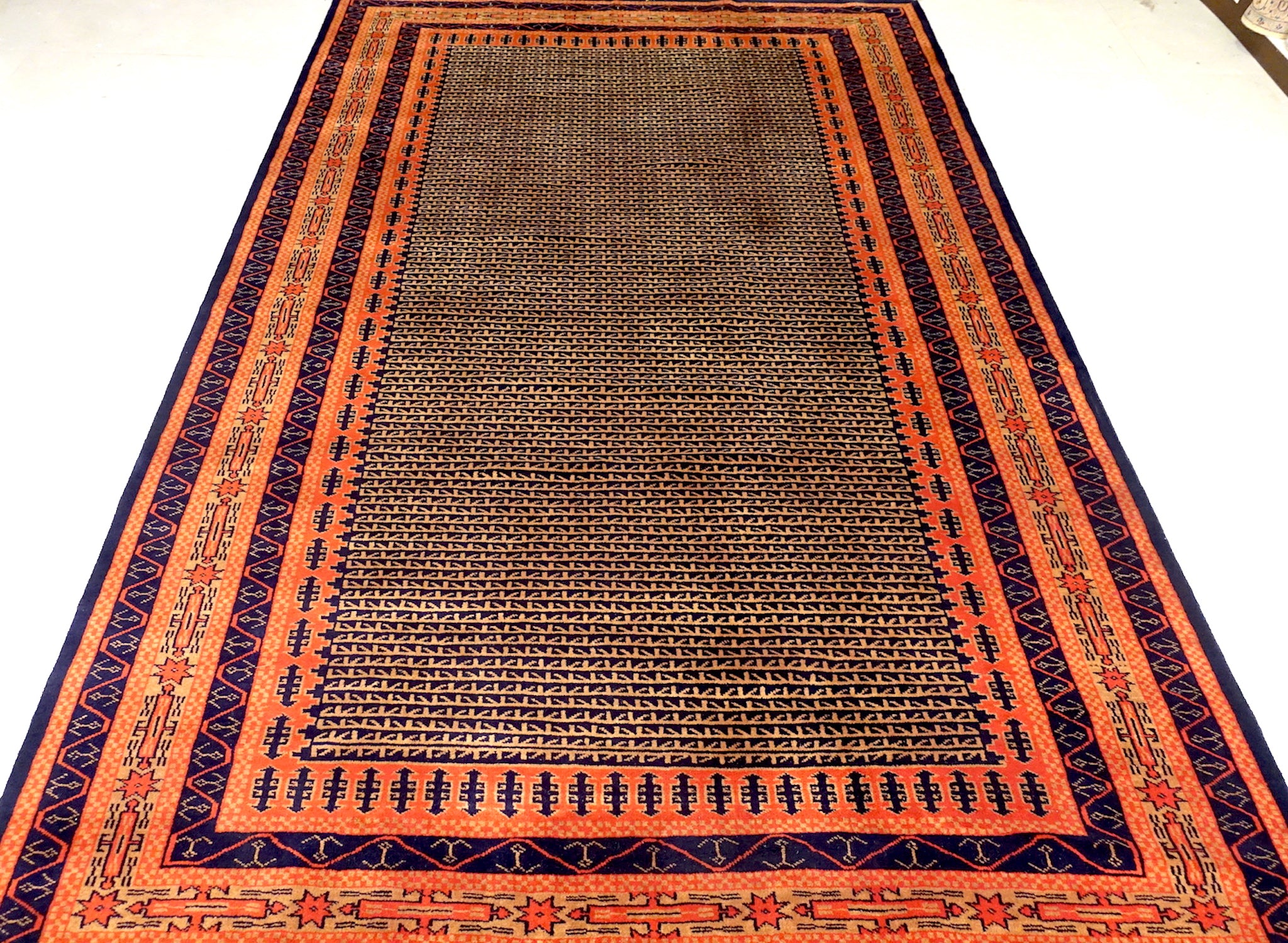 A 6 feet by 9 feet indian wool rug, the colours used on the rug are rust,brown,orange and dark blue.
