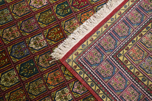 A 6 feet by 9 feet Kashmiri woolen rug, the colours used on the rug are red,orange,green, beige and blue.