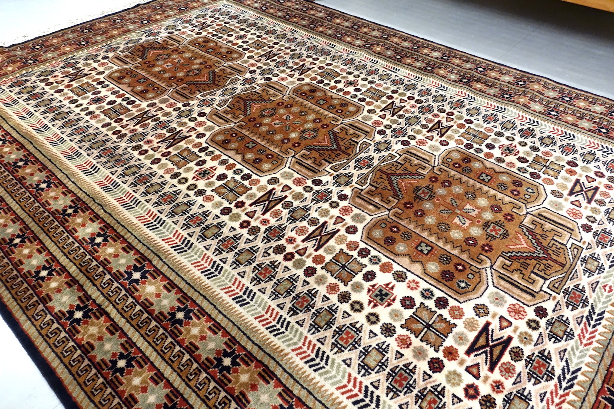 It is a 6 feet by 9 feet Indian wool rug. The colours used are rust,beige,blue and brown. 