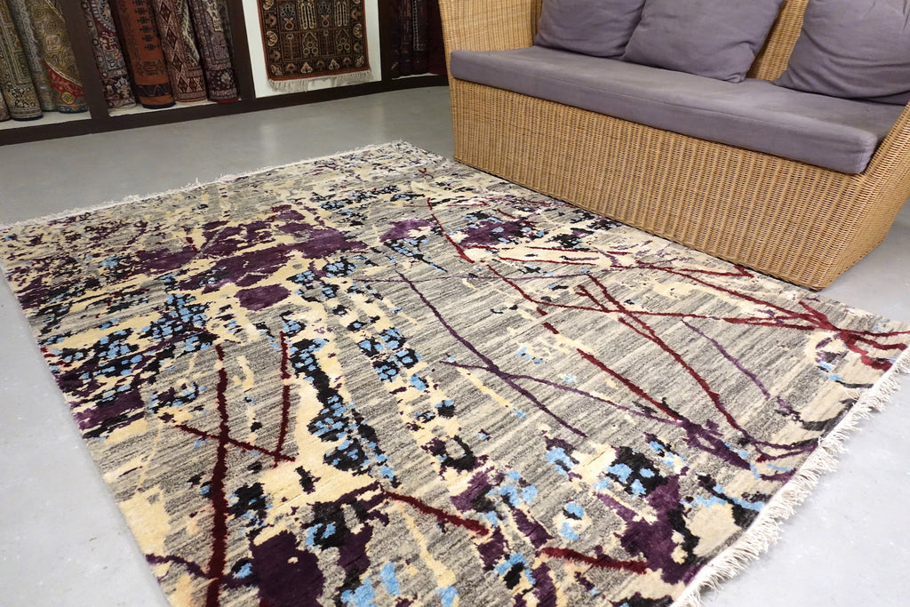 The rug/carpet consists of modern design. With a striped black and white based. Purple and Blue sprawled across like ink spread on paper. The rug is 5 feet by 7 feet. 