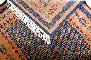 A 4 feet by 6 feet indian wool rug, the colours used on the rug are rust,brown and dark blue.
