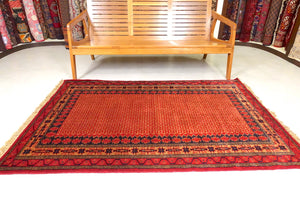 A 4 feet by 6 feet indian wool rug, the colours used on the rug are rust,brown,orange and dark blue.