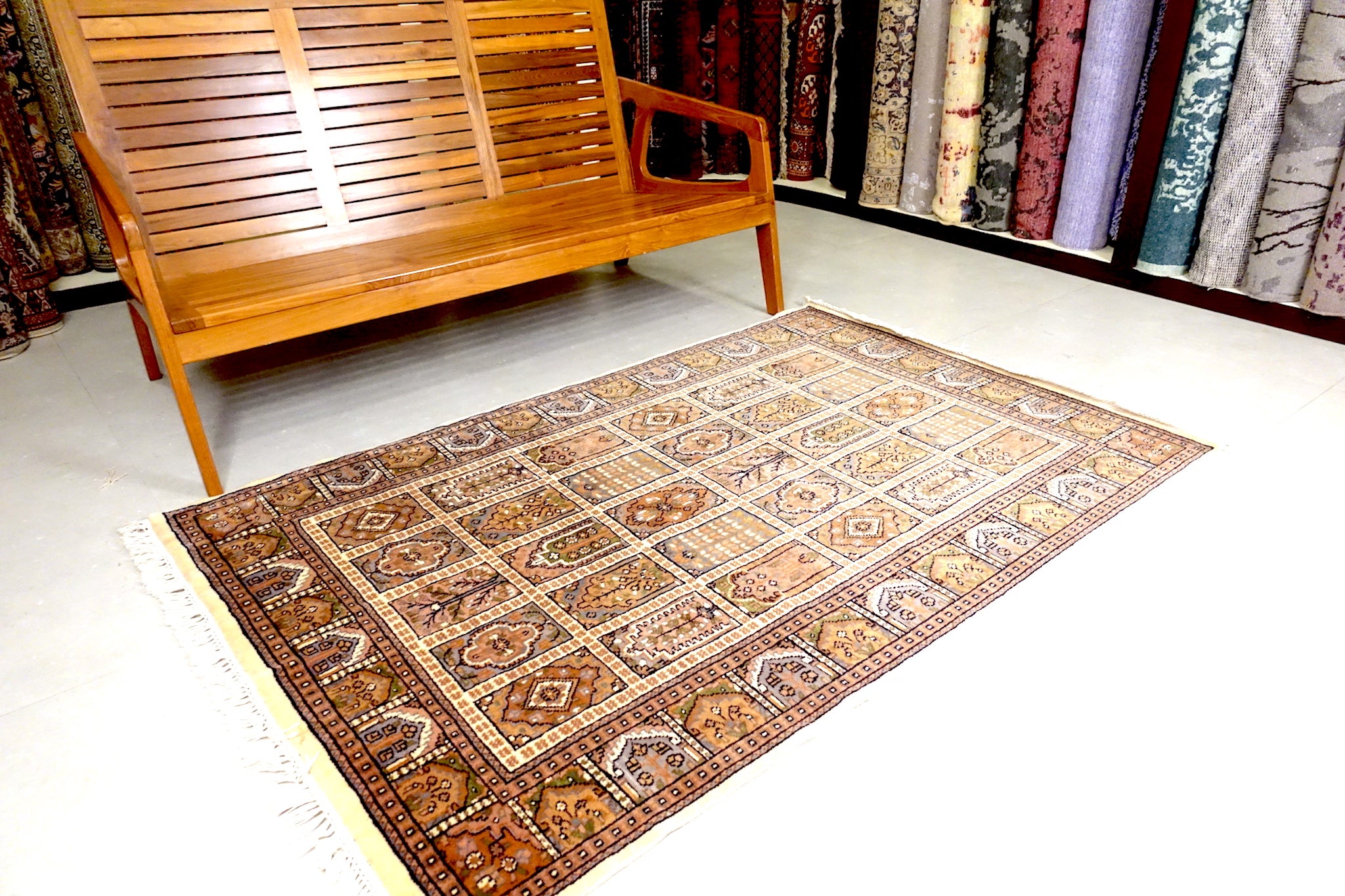It is a 4 feet by 6 feet Indian wool rug. The colours used on the rug are beige,green and brown.