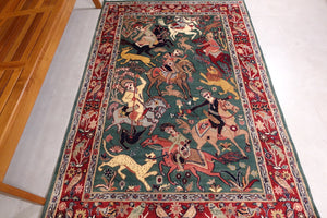 It is a 4 feet by 6 feet persian wool rug. It depicts a hunting scene and the colours used are gree,beige,red and black.