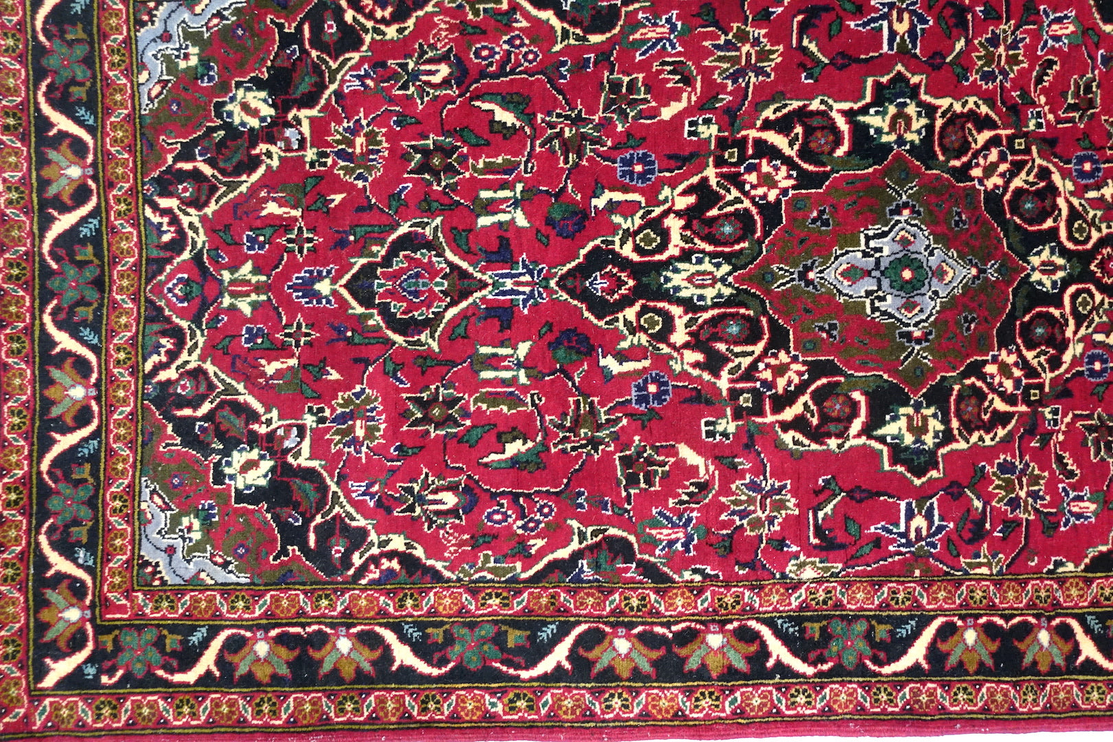 A 3.5 feet by 6 feet Afghan wool carpet, the colours used on the rug are pink, black, green, beige and brown. 