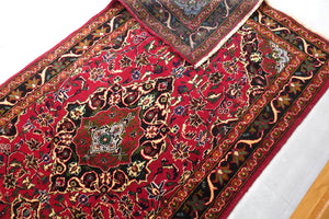 A 3.5 feet by 6 feet Afghan wool carpet, the colours used on the rug are pink, black, green, beige and brown. 