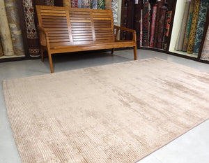 A 5 feet by 8 feet rug in brown.