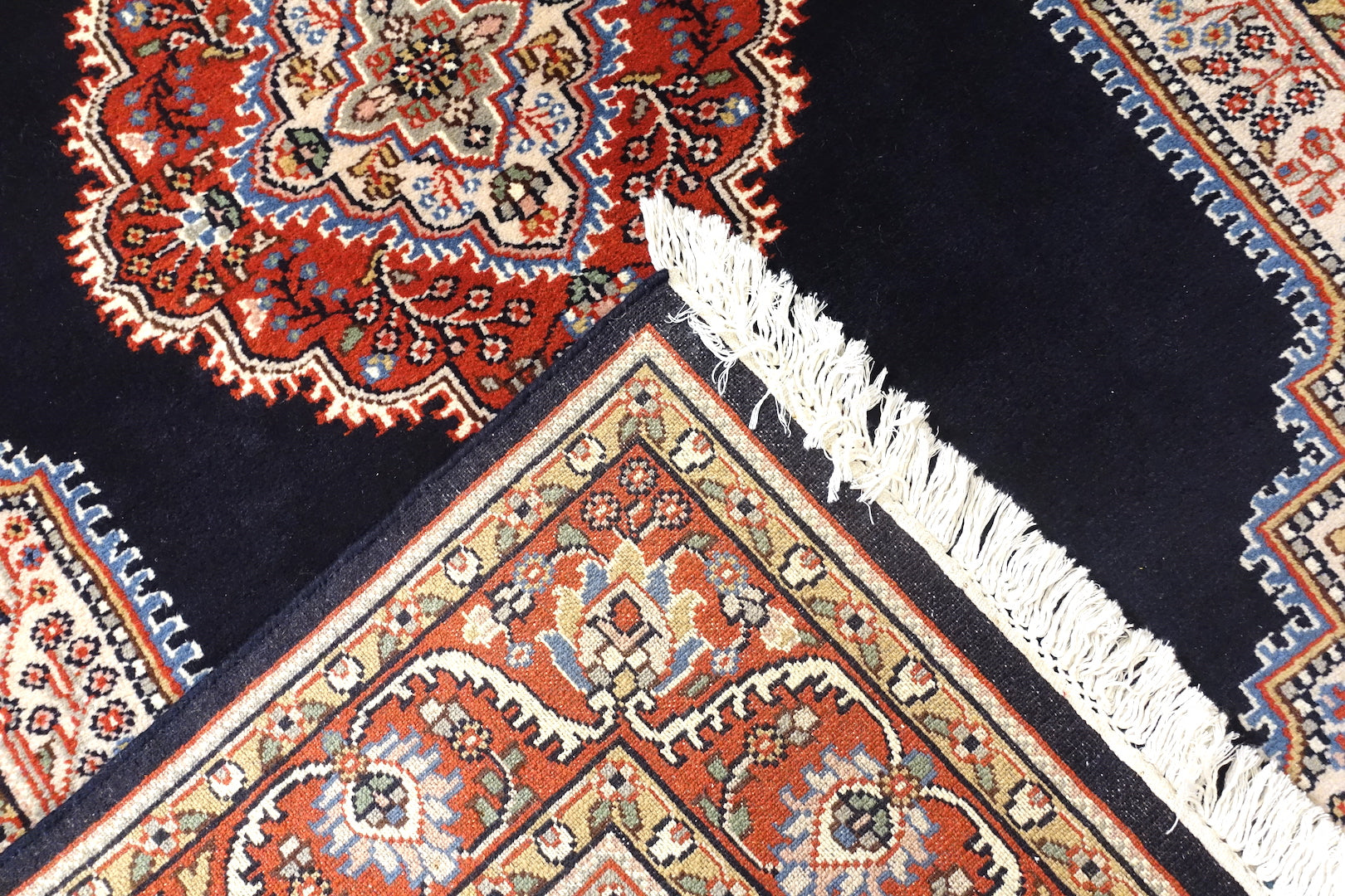 A 4 feet by 6 feet central Indian wool rug. The colours used are dark blue, beige,cream,red and brown.