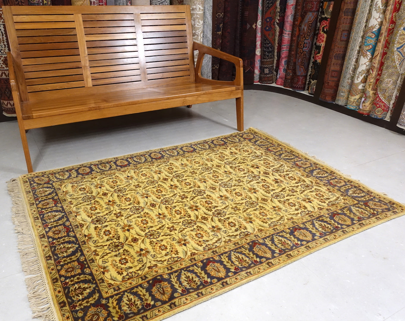 It is a 4 feet by 6 feet Indian wool rug with yellow, dark blue, rust and cherry colours.