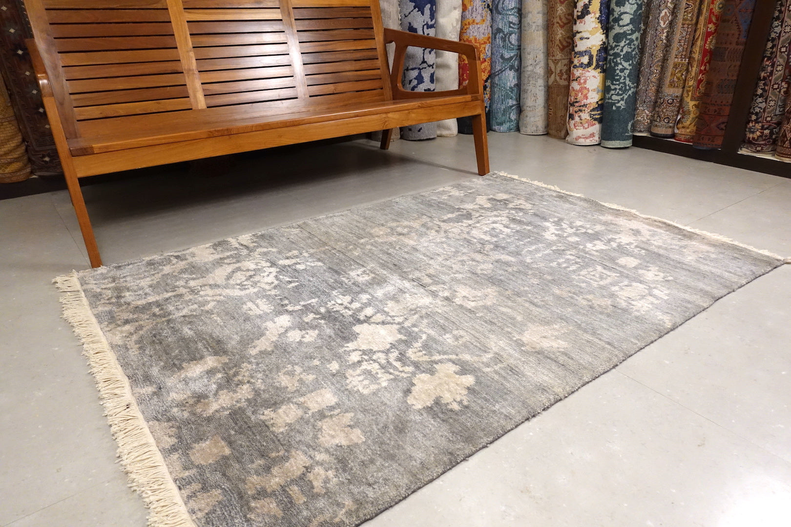 This 4 feet by 6 feet rug is an abstract floral design with pastel shades. The colours are gray and white.