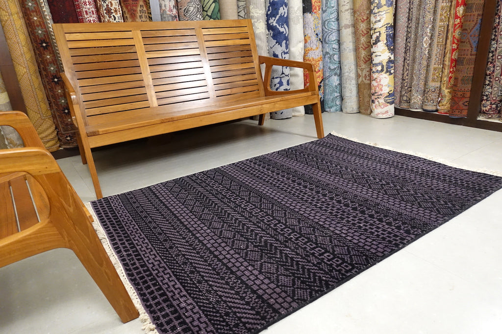An almost 4 feet by 6 feet rug with a geometric patterns.