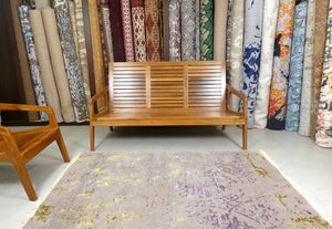 A 4 feet by 6 feet rug with an erased design in light purple as a based with sprinkle of yellow and darker purple.