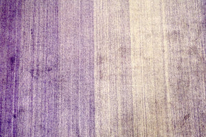A 4.5 feet by 8 feet rug that is purple and fades inwards with white.