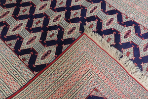 A 5 by 6 feet afghani wool rug. The colours used on the carpet are red, deep blue and beige.