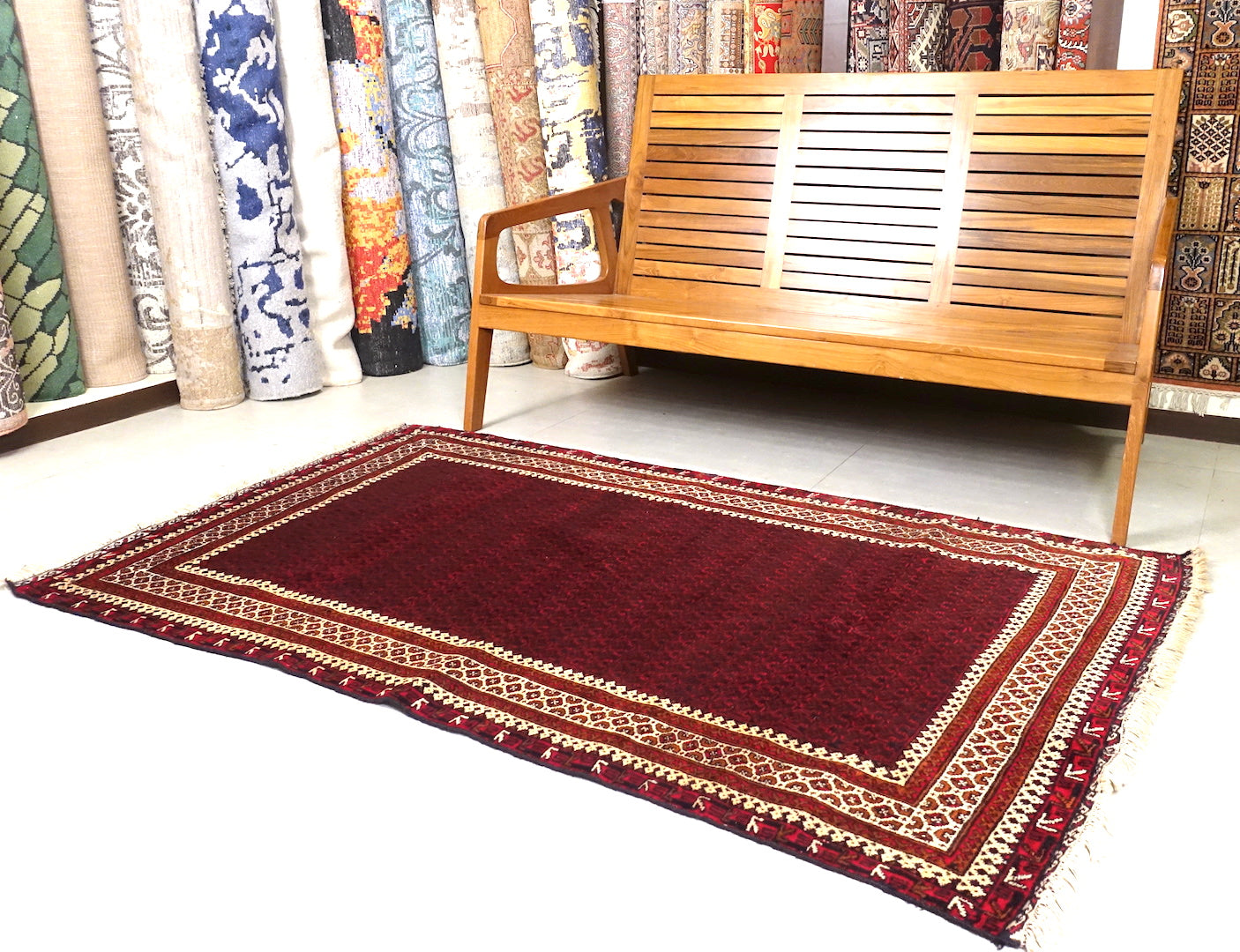 It is an Afghan wool rug that measures 3 feet 9 inches by 6 feet 4 inches. The colours used on the rug are red,beige and rust.