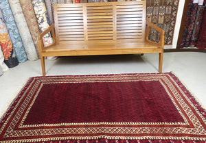 It is an Afghan wool rug that measures 3 feet 9 inches by 6 feet 4 inches. The colours used on the rug are red,beige and rust.