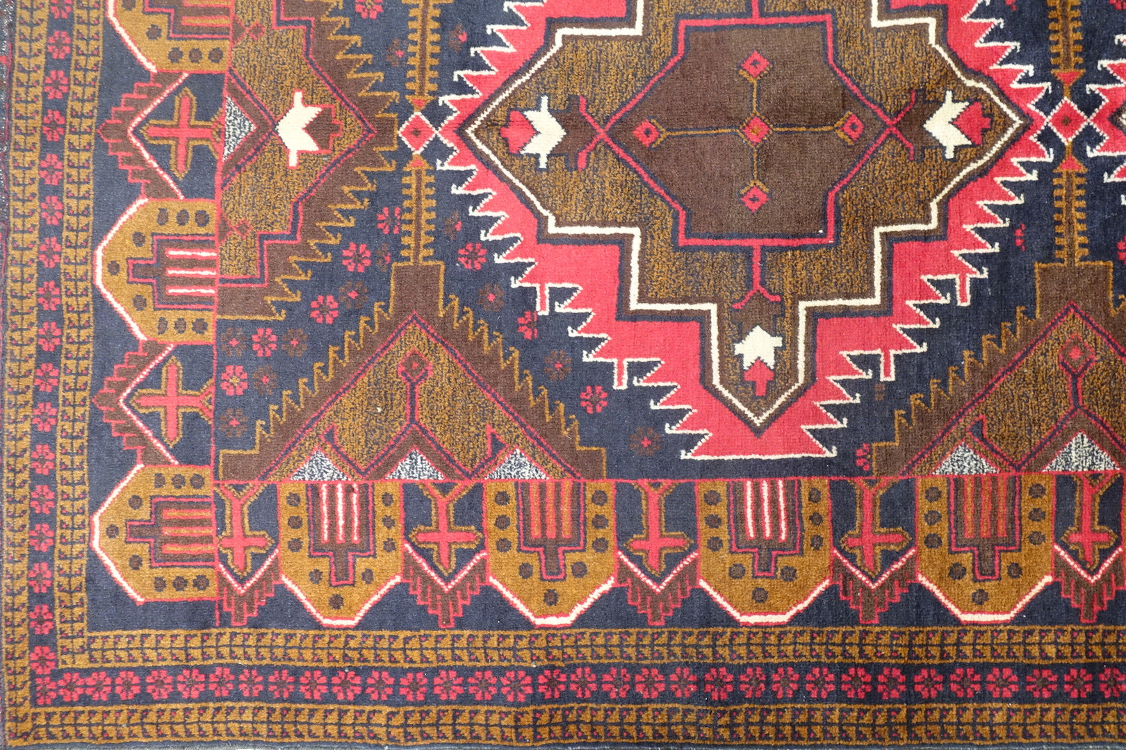 A 4 feet by 7.5 feet Balochi wool rug, the colours used are red, orange and blue.