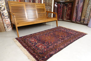 It is a 3.5 feet by 6 feet Afghan wool rug. The colours used are dark blue, brick red and rust.