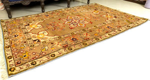 It is a 4 feet by 7 feet Indian wool rug. The colours of rust, beige, black and brick red are used on the rug.