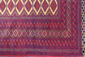 A 4 by 6 feet afghani wool rug. The colours used are red, cherry and tan.
