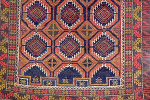 A 3.5 by 6 feet balochi wool carpet, the colours used on the rug are navy blue, orange and pink-red.