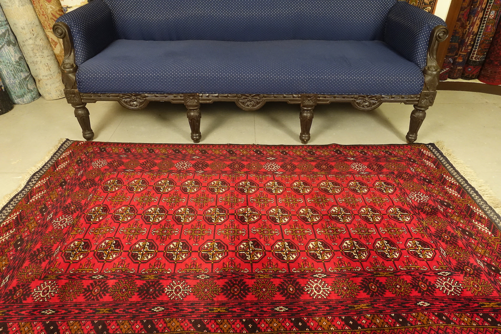 A 4 feet by 6.5 feet Afghan wool rug, the colours used on the rug are red,blue,beige and rust.