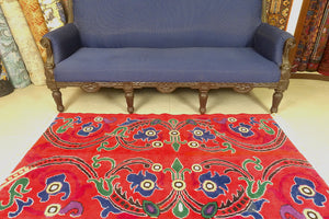 A 3 feet by 5 feet tibetian wool rug. The colours used on the rug are red,blue,beige and yellow.