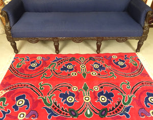 A 3 feet by 5 feet tibetian wool rug. The colours used on the rug are red,blue,beige and yellow.