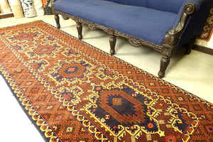 A 3 by 9.5 feet baluchi wool rug, the colours used on the rug are red,brown,beige and blue.
