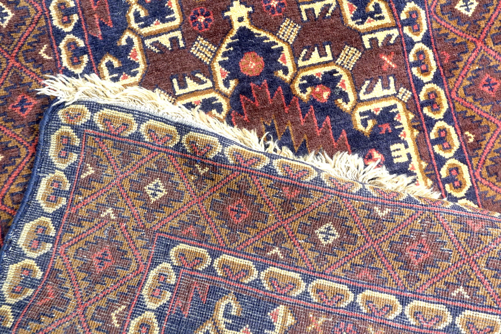 A 3 by 9.5 feet baluchi wool rug, the colours used on the rug are red,brown,beige and blue.