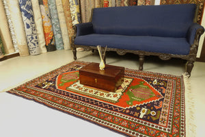 A 4 feet by 6 feet balochi wool rug, the colours used on the rug are red, green and beige.