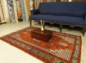 A 4 by 6 feet balochi wool rug, the colours used on the carpet are blue, brick, green and beige.