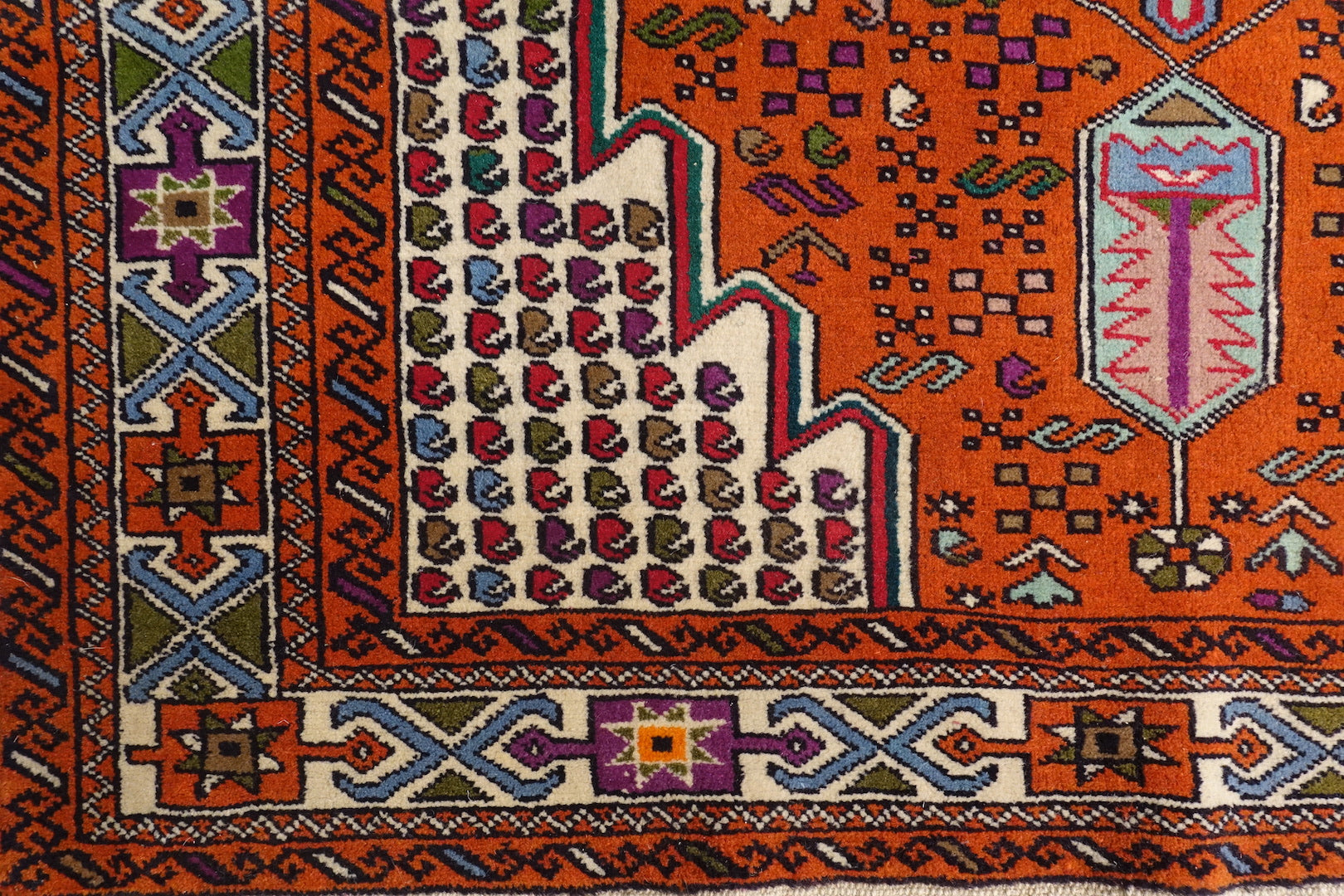 A 4 by 6 feet balochi wool rug, the colours used on the carpet are blue, brick, green and beige.