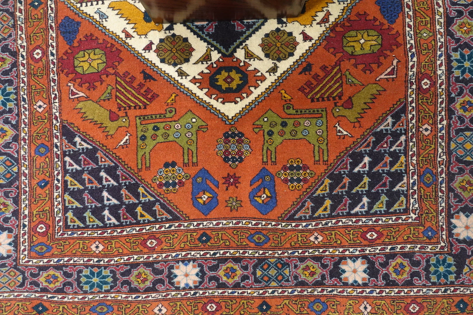A 4 by 5.5 feet zanjan wool rug. The colours used are orange,brown,blue,red and beige.