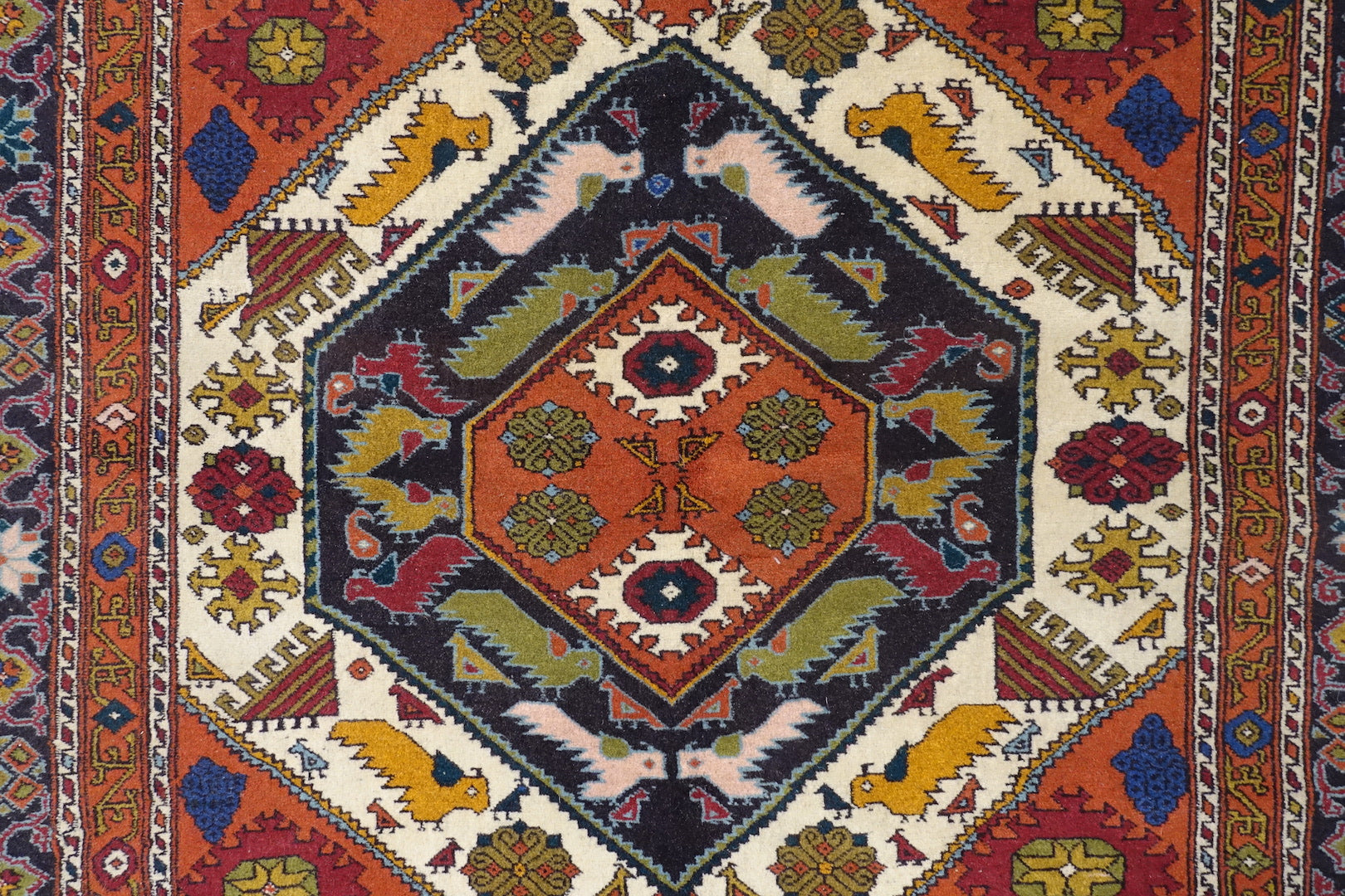 A 4 by 5.5 feet zanjan wool rug. The colours used are orange,brown,blue,red and beige.