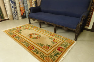A 3 by 6 feet tibetan wool rug. The colours used are red, mustard, tan, green and white.