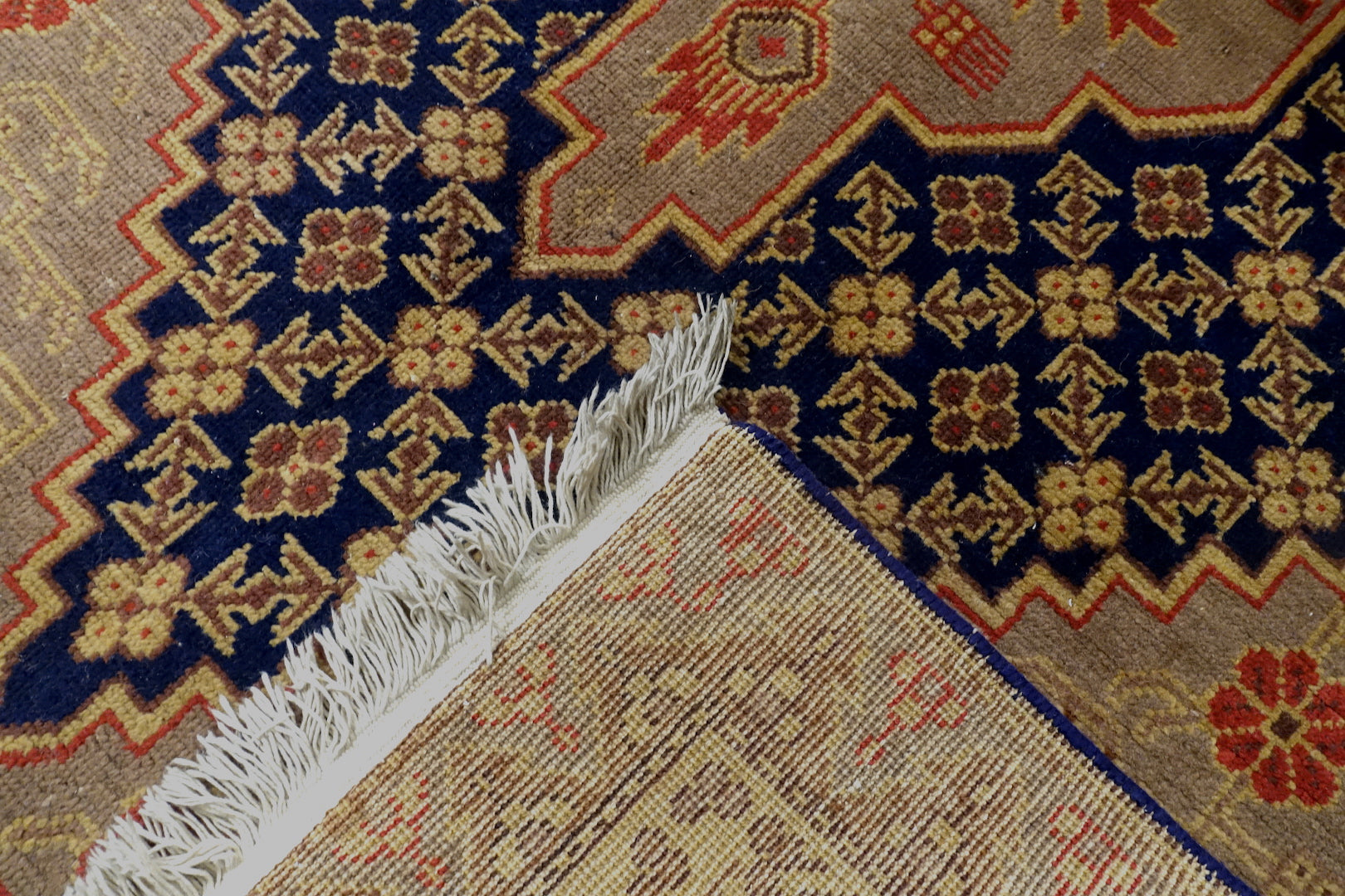 It is a 4 feet by 8 feet antique wool rug from samarkand. The colours used on the rug are orange,gold and blue.