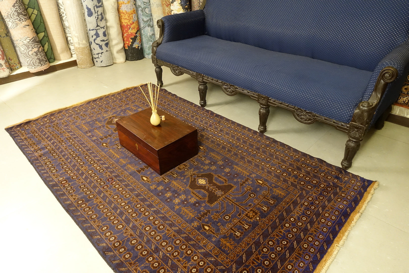 A 4 by 7 feet afghan wool rug. The colours used are typically blue, brown, beige and tan.