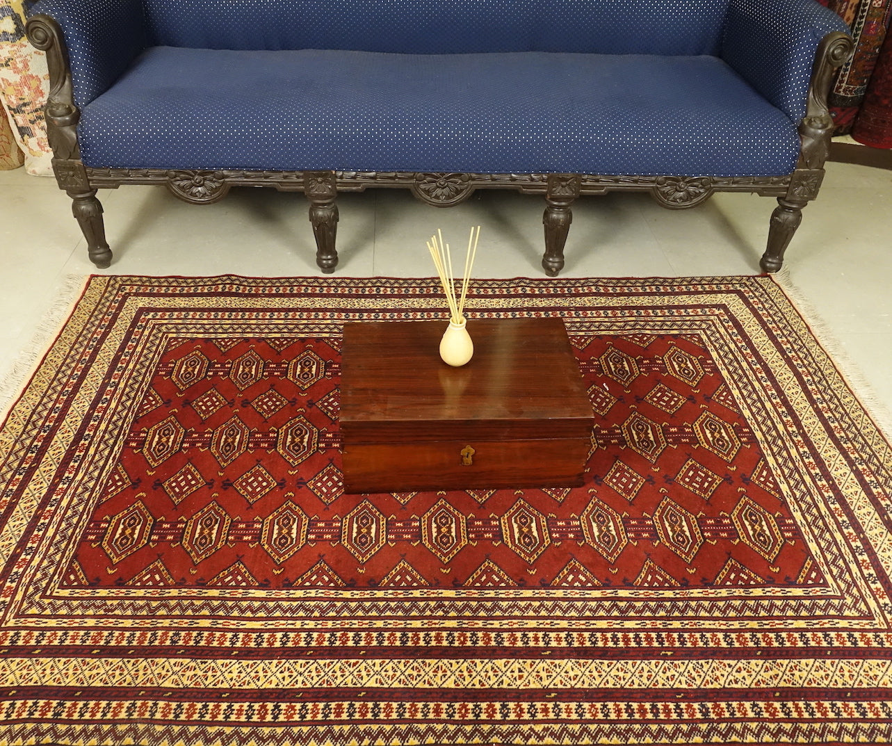 A 4 by 6 feet afghani wool rug. The colours used on the carpet are red, tan, deep blue and beige.
