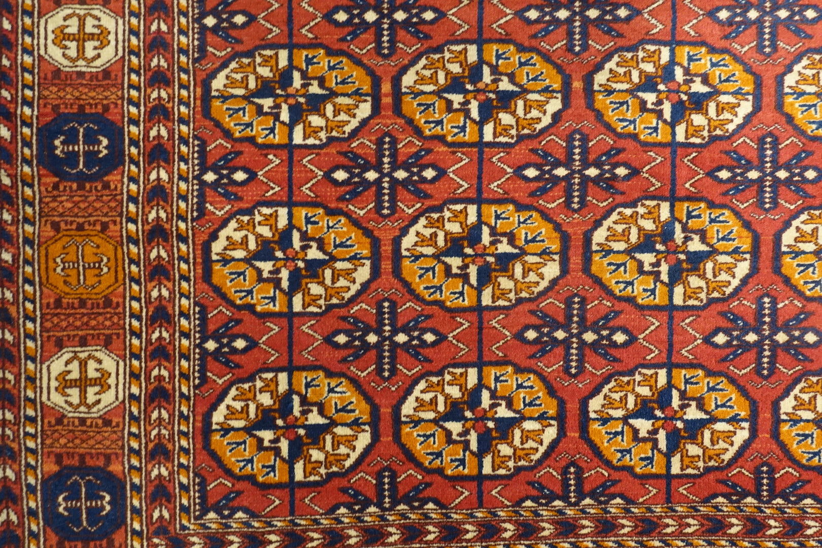 It is a 4 feet by 6 feet wool rug made by jail inmates in central India. The colours used are rust,orange,red,blue and yellow.