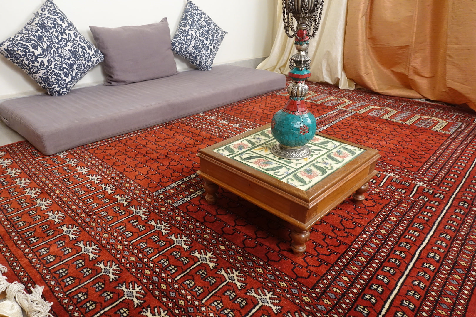 It is a 5 feet by 7 feet rug, the colours used are brick red, black, blue and beige.