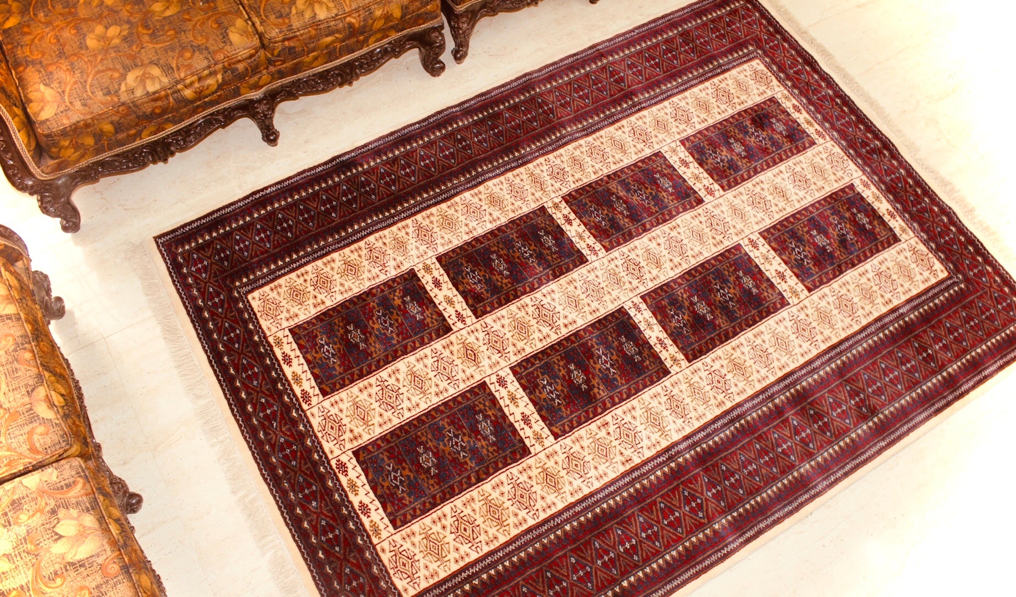 A 5 feet by 7 feet indian wool rug, the colours used are deep red, rust, blue and white.